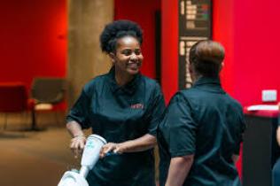 Two staff members talking whilst cleaning an office