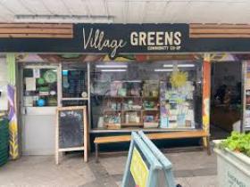 Picture of the shop front and entrance including a sign stating Village Greens Coop